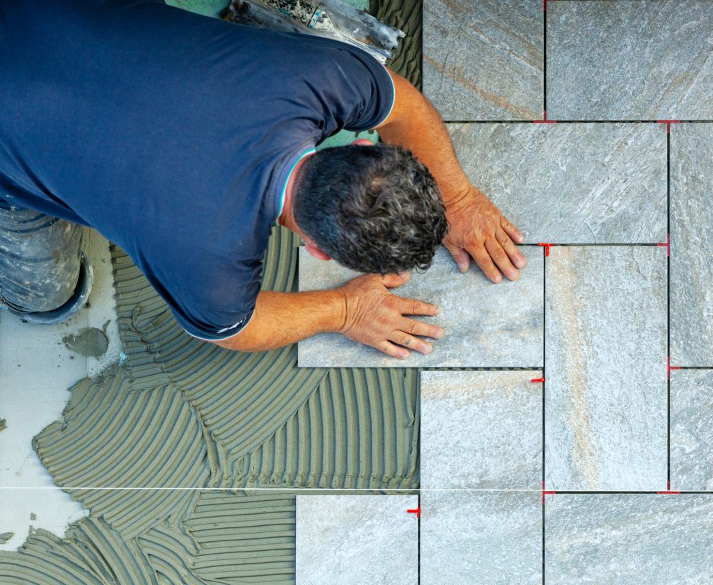 Tiler carefully lays every single tile with the help of a wire to respect the geometry.